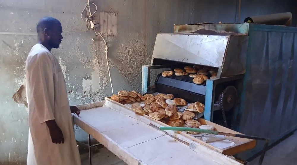 عامل في مخبز بأم درمان يشرف على إنتاج الخبز (الشرق الأوسط)