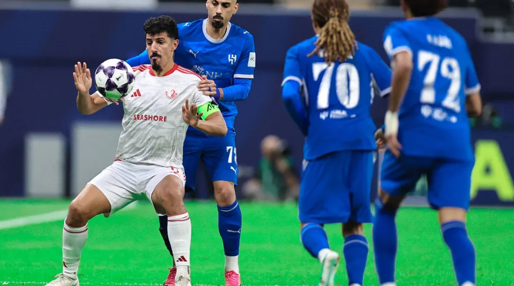 الجزائري بغداد بونجاح، مهاجم الشمال القطري في صراع على الكرة مع لاعبي الهلال (تصوير: سعد العنزي) 