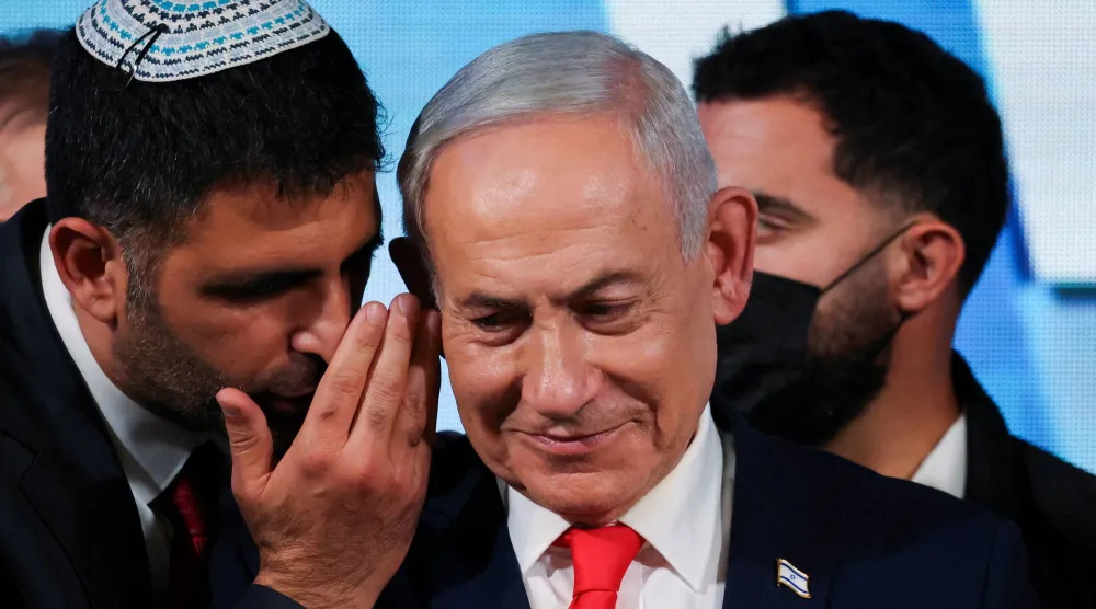 أحد المساعدين يتحدث لرئيس الوزراء الإسرائيلي وزعيم حزب «الليكود» بنيامين نتنياهو بينما يدلي بتصريح عقب صدور استطلاعات الرأي عند الخروج من مراكز الاقتراع بالانتخابات الوطنية في مقر الحزب بالقدس (رويترز)