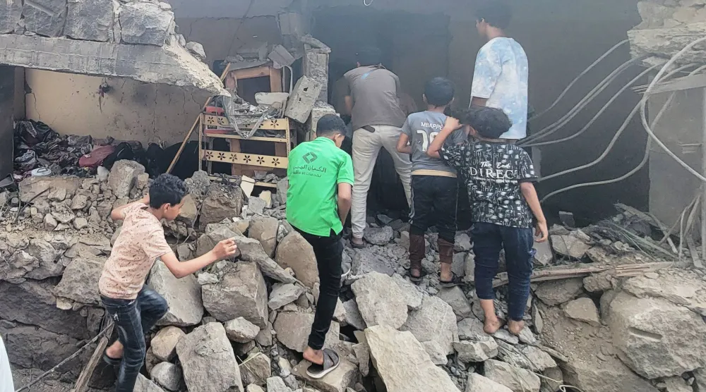 Residents walk amid debris from their homes after a missile strike in Seina, Taiz, Yemen, Tuesday, Oct. 20, 2026. (AP Photo/Marzouq Al Jabri)
