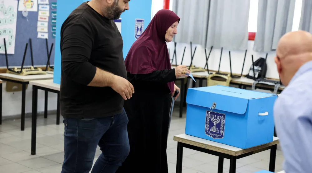 ناخبة من عرب إسرائيلية تدلي بصوتها في لجنة بمدينة أم الفحم شمال إسرائيل يوم الثلاثاء (رويترز)