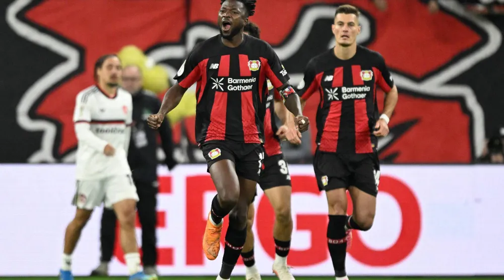 إدموند تابسوبا مدافع باير ليفركوزن يحتفل مع زملائه بتسجيل هدف التعادل (2-2) أمام نورمبرغ  (أ.ف.ب)