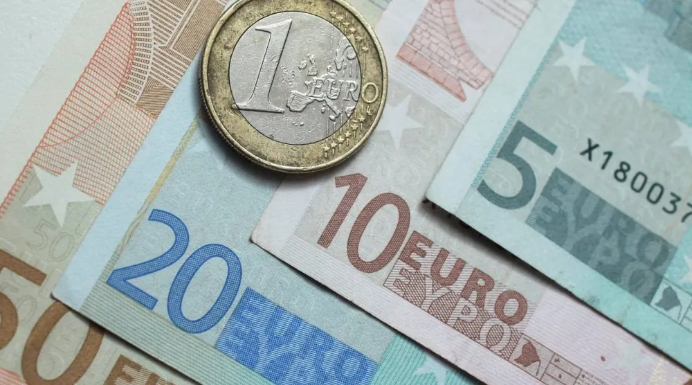 قطعة نقدية من فئة يورو واحد فوق أوراق نقدية باليورو (غيتي)