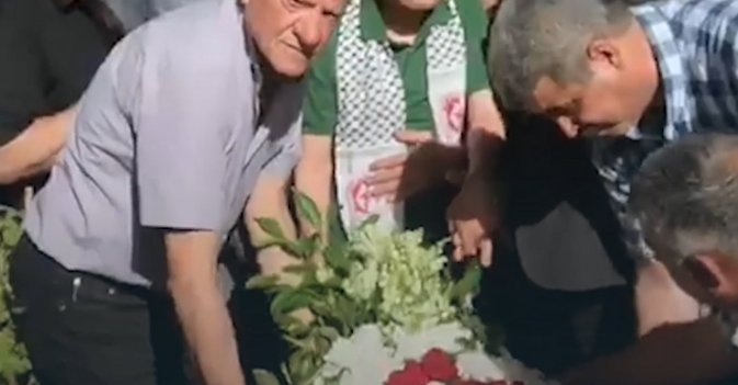 كوزو أوكوموتو يضع إكليلا من الزهر على الضريح الرمزي الذي يحتوي عظام ومتعلقات "صلاح الياباني"