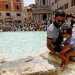 أشخاص يبردون أنفسهم في نافورة تريفي في روما بإيطاليا خلال موجة حارة في جميع أنحاء البلاد في 20 يوليو 2023 (رويترز)