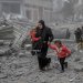 سيدة فلسطينية وأطفالها يفرّون (الاثنين) من قصف إسرائيلي استهدف وسط مدينة غزة (أ.ف.ب)