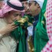 الملك سلمان مقبّلاً العلم السعودي (واس)