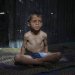 أحمد الشيخ عيد (7 سنوات) تظهر عليه علامات سوء التغذية ويقف لالتقاط صورة في خيمة عائلته بمخيم للنازحين الفلسطينيين في مواصي خان يونس (أ.ب)