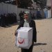 امرأة فلسطينية تحمل صندوق مساعدات في مدينة غزة (أ.ب)