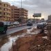 مواطن يحاول تصريف المياه من أمام مسكنه في مدينة أم درمان (الشرق الأوسط)