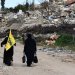مناصرتان لـ«حزب الله» تسيران إلى جانب الركام الناتج من القصف الإسرائيلي في بلدة كفر كلا الحدودية مع إسرائيل فبراير الماضي (أرشيفية - رويترز)