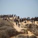 فلسطينيون متجمعون على تلة في النصيرات بوسط قطاع غزة الأربعاء ترقباً لإنزال مساعدات إنسانية جواً (أ.ف.ب)