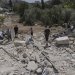 فلسطينيون يتفقدون أنقاض منزل بعد هدمه من قبل الجيش الإسرائيلي في قرية بيت سيرا بالضفة الغربية (أ.ب)
