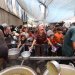 فلسطينيون يتجمعون لتسلم وجبات طعام مطبوخة من مركز توزيع أغذية في مخيم النصيرات للاجئين وسط قطاع غزة (أ.ف.ب)