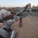 طفلة فلسطينية بجانب أطلال مبنى مدمر في مخيم البريج للنازحين بوسط قطاع غزة (أ.ف.ب) 