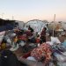أسرة فلسطينية نازحة تضع أمتعتها عند خيمة في مخيم البريج بوسط قطاع غزة يوم الأربعاء (أ.ف.ب)
