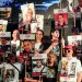 إسرائيليون يحملون لافتات عليها صور الرهائن في «ساحة الرهائن» بتل أبيب (رويترز)
