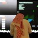 مستثمر يراقب شاشة التداول في «السوق المالية السعودية» بالرياض (أ.ف.ب)
