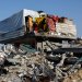 فلسطينيون يقفون على أنقاض منزل في شمال قطاع غزة يوم الأربعاء (رويترز)