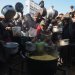 تجمُّع فلسطينيين نازحين لتلقي حصص غذائية في مطبخ خيري بخان يونس جنوب قطاع غزة (أ.ف.ب)