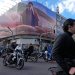 أشخاص يقودون دراجاتهم النارية أمام لوحة إعلانية تعرض صورة للمرشد الجديد مجتبى خامنئي في وسط طهران (أ.ب)