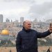 فلسطيني يلتقط صورة سيلفي مع المسجد الأقصى يوم الأربعاء الذي ظل مغلقاً منذ بدء الحرب (أ.ف.ب)