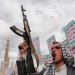 عنصر حوثي يرفع بندقية خلال حشد في صنعاء للتضامن مع إيران و«حزب الله» اللبناني (رويترز)