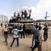 فلسطينيون فوق دبابة إسرائيلية سيطر عليها مقاتلو «كتائب القسام» قرب خان يونس يوم 7 أكتوبر 2023 (د.ب.أ)