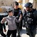 عناصر من الشرطة الإسرائيلية يعتقلون أطفالاً فلسطينيين في الخليل بالضفة الغربية (أ.ف.ب)