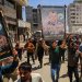 فلسطينيون يحملون صورة كبيرة للقائد عز الدين الحداد خلال تشييعه في مدينة غزة يوم السبت (رويترز)
