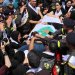 مشيعون يشاركون في جنازة عنصرين من الدفاع المدني اللبناني قتلا في غارة إسرائيلية على مدينة النبطية في 13 مايو 2026 (رويترز)
