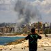 لبناني يوثق الدخان الناتج عن غارة إسرائيلية استهدفت مدينة صور الساحلية بجنوب لبنان (د.ب.أ)
