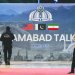 رجل أمن أمام لوحة لمحادثات إسلام آباد خارج مركز إعلامي أُقيم لتغطية المفاوضات بين الولايات المتحدة وإيران (أ.ب)