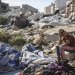  صبي فلسطيني يجلس في موقع غارة عسكرية إسرائيلية استهدفت مباني وخياماً تؤوي عائلات نازحة في غزة (أ.ف.ب)