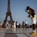 مواطن يأكل المثلجات أمام برج إيفل في باريس (رويترز)