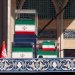 نعوش المرشد الإيراني علي خامنئي وأفراد عائلته بألوان العلم الإيراني على المنصة (رويترز)