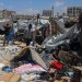فلسطينيون يتفقدون موقع غارة إسرائيلية استهدفت خيمة في مخيم لإيواء النازحين بمدينة غزة (رويترز)