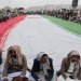 حوثيون في صنعاء يجلسون حول العلم الإيراني (رويترز)