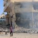 أطفال فلسطينيون يقفون بجوار مبنى مدمر في شارع الجلاء عقب غارة إسرائيلية في مدينة غزة (أ.ف.ب)