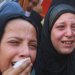 فتاتان تنتحبان خلال جنازة فلسطينيين قُتلوا في غارات إسرائيلية استهدفت خياماً في خان يونس جنوب غزة (رويترز)