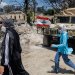 مواطنتان تمران أمام آلية عسكرية للجيش اللبناني أثناء انتشار الجيش بالمنطقة التجريبية الأولى في زوطر الغربية (رويترز)