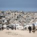 فلسطينيون يسيرون وسط أنقاض المباني المدمرة في مخيم جباليا للاجئين شمال قطاع غزة (أ.ف.ب)
