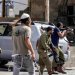 مستوطنون وجنود إسرائيليون مسلّحون في بلدة حوارة بالضفة الغربية المحتلة (أرشيفية - أ.ف.ب)