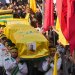 يحمل عناصر من كشافة «حزب الله» نعوش القيادي علي الحاج حسن وزوجته وأطفاله الأربعة الذين قُتلوا السبت في غارة إسرائيلية وذلك خلال موكب تشييعهم بالضاحية الجنوبية يوم الأحد (أ.ب)