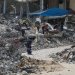فلسطينيون يستخرجون المعادن من أنقاض المنازل المدمرة في خان يونس لإعادة استخدامها في صنع الخيام بغزة (د.ب.أ)