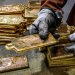 عامل مصفاة يقوم بتكديس سبائك الذهب بعد إخراجها من قوالبها في مصهر مصفاة في سيدني (أ.ف.ب)