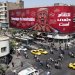 إيرانيون يقودون سياراتهم بالقرب من لوحة إعلانية مناهضة لترمب في طهران (إ.ب.أ)
