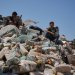 فلسطينيون في مستودع للمساعدات الغذائية تضرر من غارة إسرائيلية استهدفت منزلاً مجاوراً في دير البلح وسط غزة الأربعاء (أ.ب)