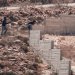 مستوطنون إسرائيليون بالقرب من منزل فلسطيني في قرية قصرة بالضفة الغربية (أ.ف.ب)