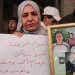 سوريّة تحمل صور أقارب لها قُتلوا في «مجزرة التضامن» بالحي جنوب دمشق 24 أبريل الماضي (إ.ب.أ)